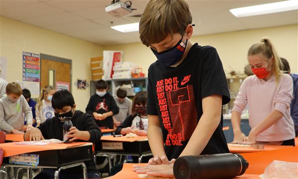 Boy cuts out shape from salt dough